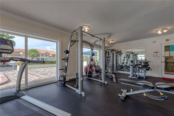 Interior view of a gym with exercise equipment and large windows.