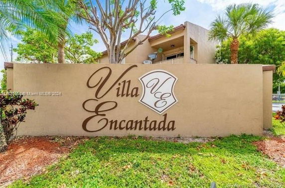 Front view of a multi-story building with a prominent sign reading 'Villa Encantada'.