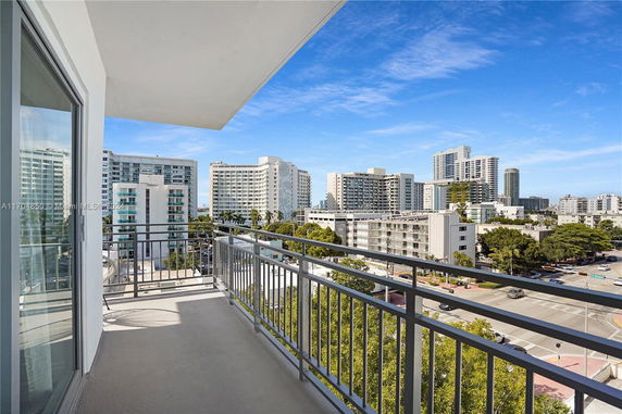 Panoramic view from a balcony overlooking multiple multi-story buildings.