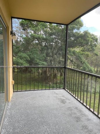 View from a building balcony with a railing overlooking trees.