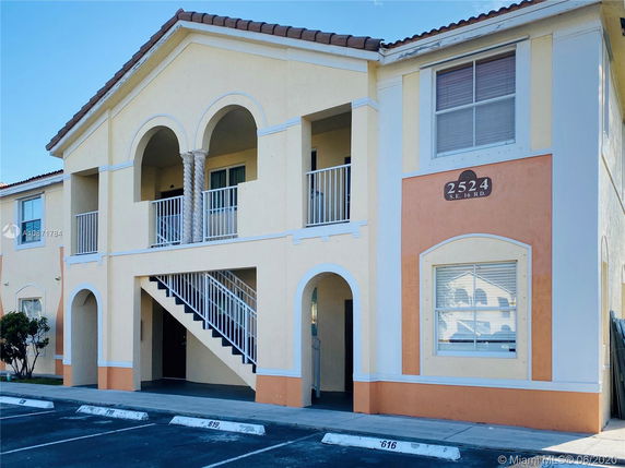 Front view of a two-story building with arches and a staircase.