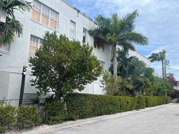 Front view of a multi-story building with a flat roof and large windows.
