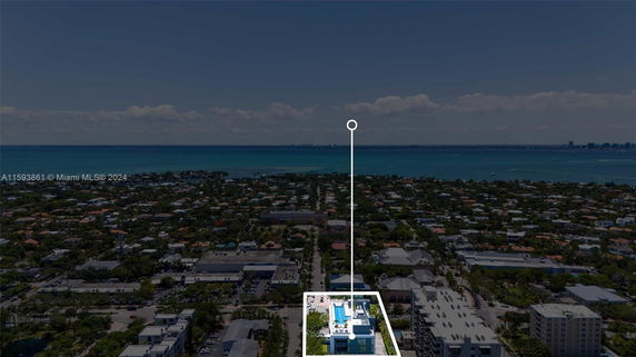 Aerial view of a cityscape with a focus on a residential area and ocean in the distance.
