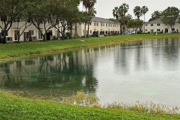 View of a pond surrounded by residential buildings.