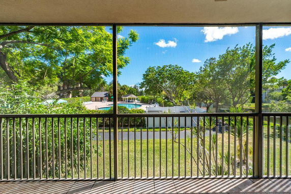 View of surrounding areas from a building, showing trees and a pool.