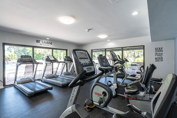 Interior view of a gym with various exercise equipment, including treadmills and stationary bikes.