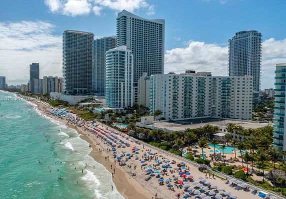 Aerial view of beachfront high-rise buildings with adjacent beach and ocean.