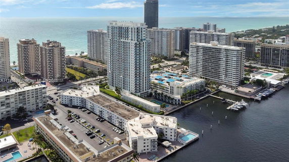 Aerial view of waterfront cityscape with multiple high-rise buildings near the ocean.