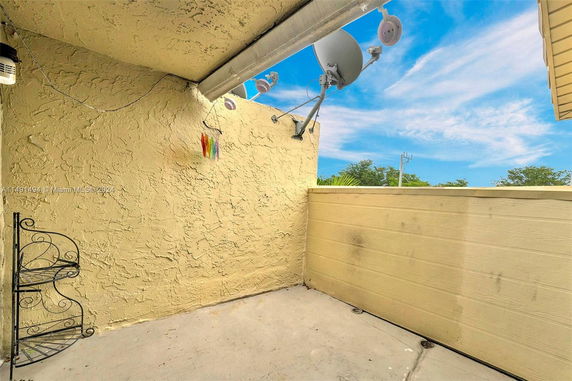 Rooftop area with satellite dish and textured wall.