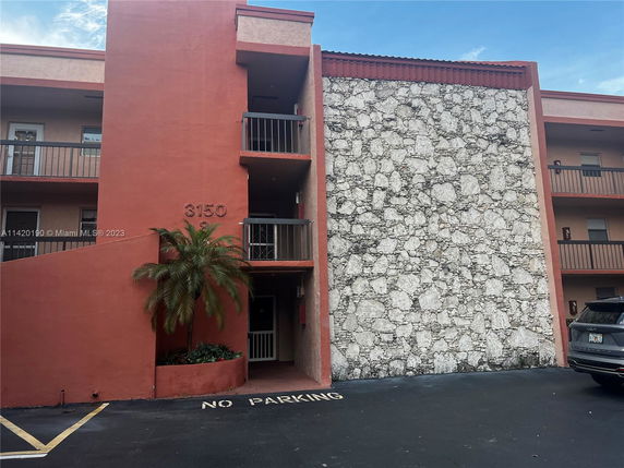 Front view of a multi-story building with stone facade and balconies.