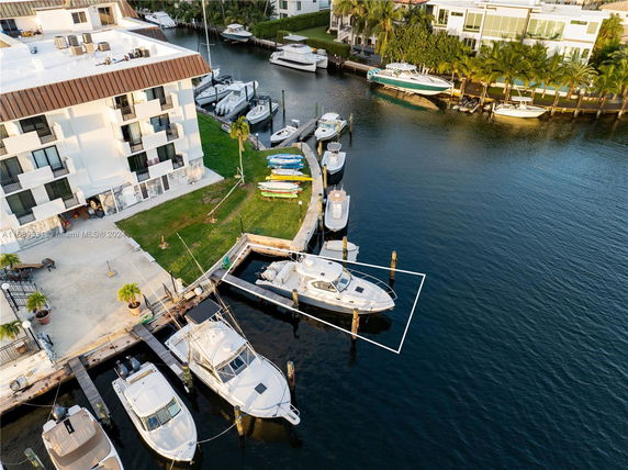 Aerial view of a building next to a marina with several boats docked.