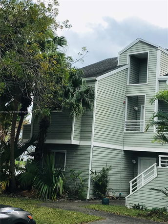 Front view of a multi-story house with a sloped roof and balcony.