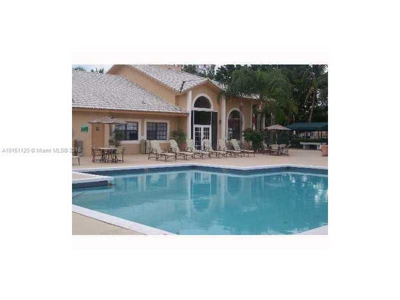 View of a building with a swimming pool in front.