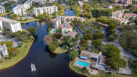 Aerial view of a residential area with multiple apartment buildings surrounded by water bodies and greenery.