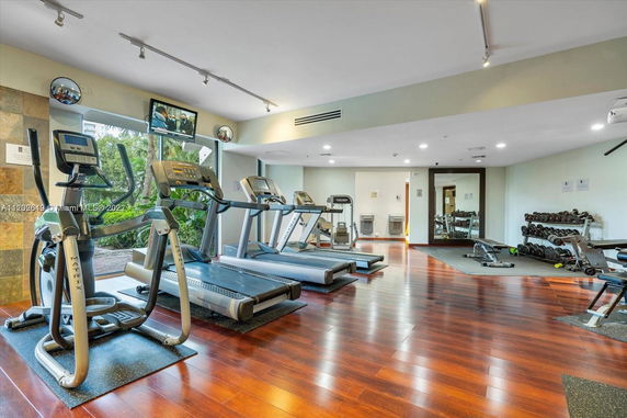 Indoor gym area with exercise equipment including treadmills and dumbbells.