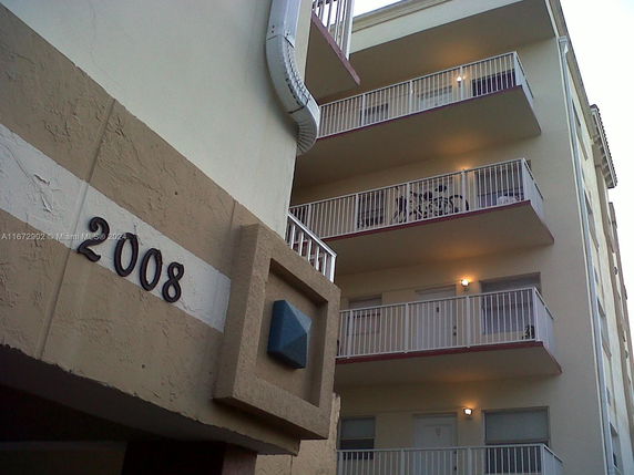 View of a multi-story building with balconies and an entrance marked with the number 2008.