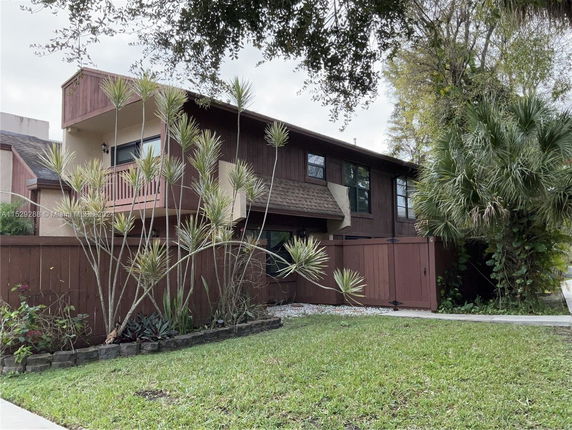 Front view of a two-story house with a wooden exterior and balcony.