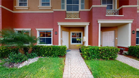 Front view of a townhouse with a covered entryway and red exterior.
