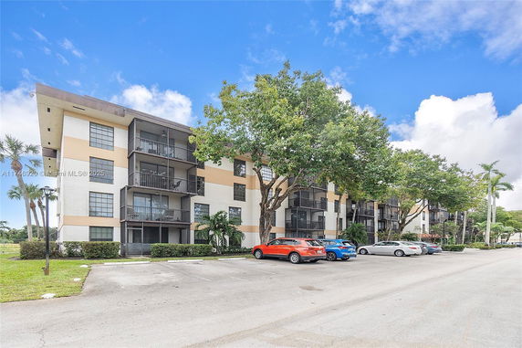 Front view of a four-story apartment building with balconies.
