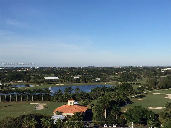 Panoramic view of a landscape with a golf course, ponds, and trees.