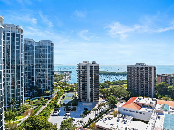 Wide-angle view of high-rise buildings and a marina with boats in the background.