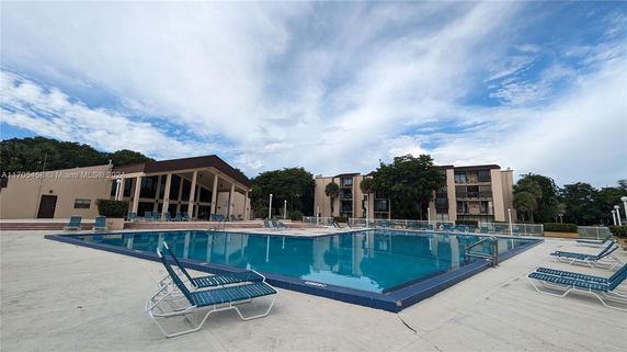 Outdoor swimming pool area with adjacent buildings.