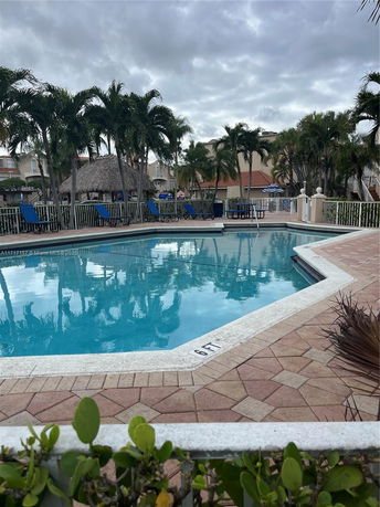 Outdoor swimming pool area with surrounding greenery and lounge chairs.