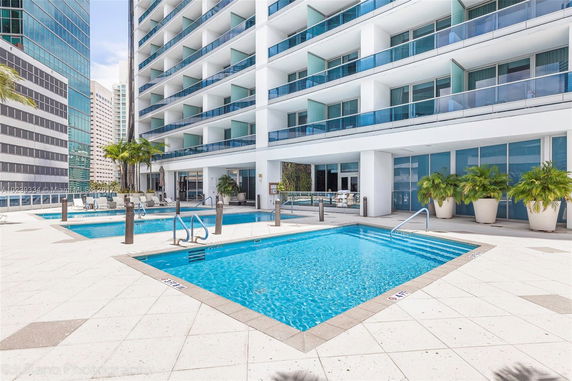 Exterior view of a modern high-rise building with a pool area.
