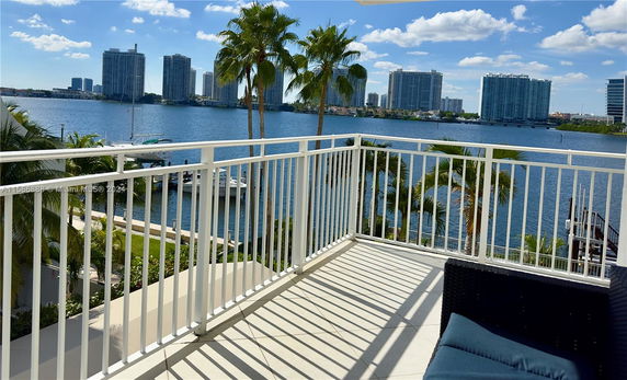 Panoramic view from a balcony overlooking a body of water and city skyline.