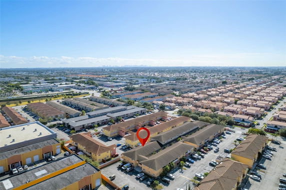 Aerial panoramic view of a residential area with multiple houses and buildings.