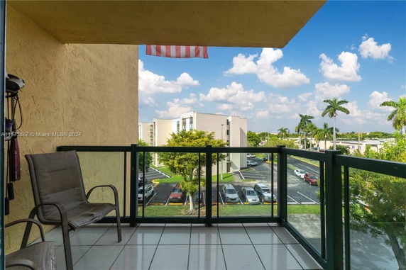 Balcony view showing surrounding buildings and parking area