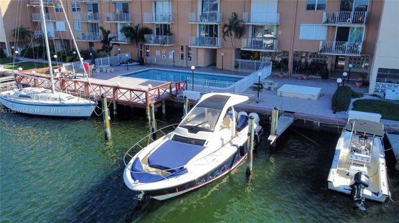 Outdoor view of a building with a swimming pool and docked boats.