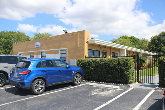Parking area in front of a single-story building.