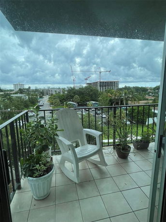 Balcony view showing distant construction cranes and cloudy sky.