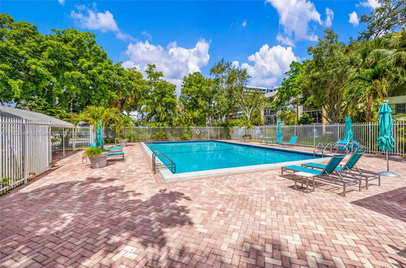 Outdoor swimming pool area with surrounding patio and lounge chairs.
