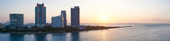 Panoramic view of tall buildings along the coastline at sunset.