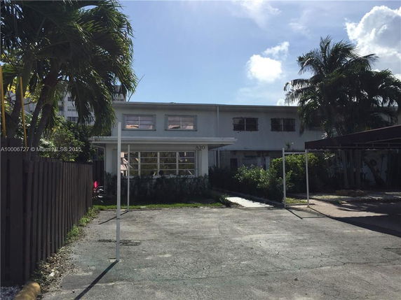 Front view of a two-story building with a flat roof and multiple windows.