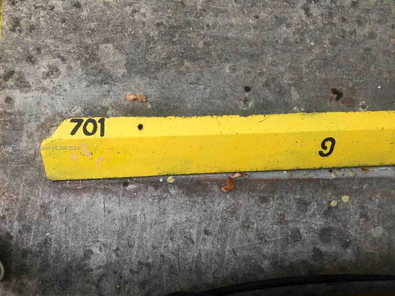 Yellow parking curb with the number 701 painted on it.
