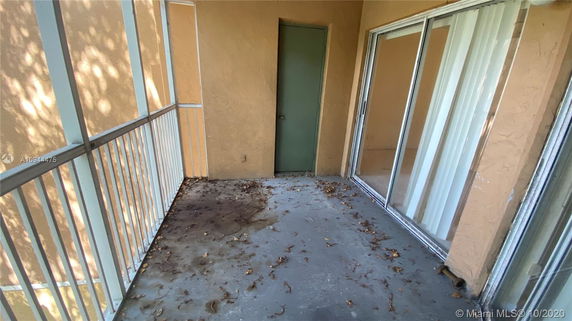 Outdoor balcony area with sliding glass doors and railing.