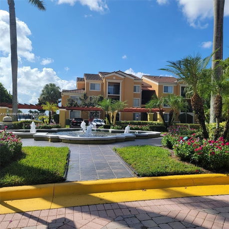 Front view of a multi-story residential building with a fountain.