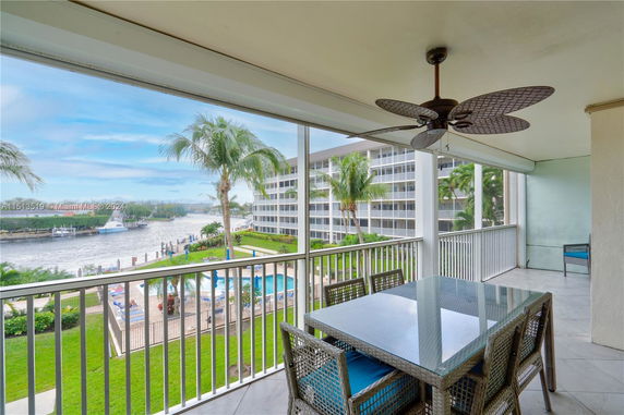 Balcony view overlooking pool area and waterway with neighboring buildings.