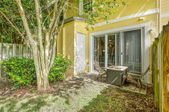 View of a yellow house exterior with sliding glass doors and a small patio area.
