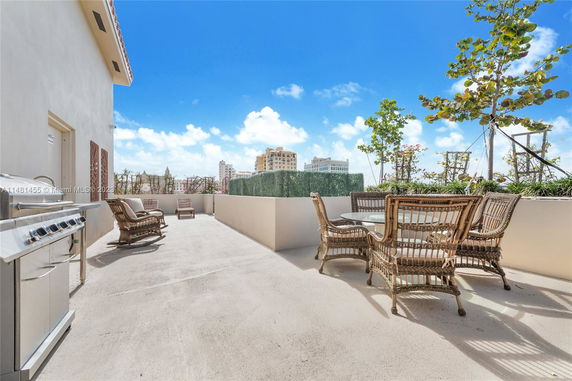 Rooftop area with outdoor seating and barbecue grill.
