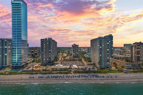 Aerial view of beachfront high-rise buildings at sunset.