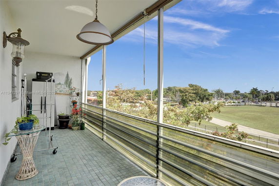 Balcony view showing a park and residential area in the background.