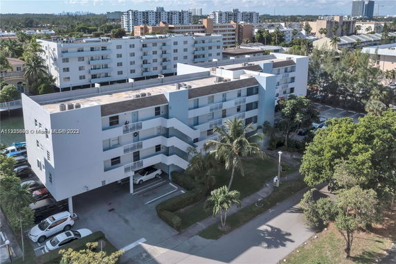 Front view of a multi-story residential building with parking area.