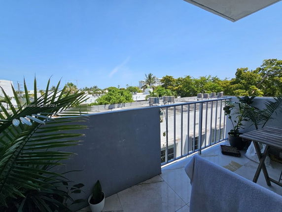 Rooftop view with plants and outdoor seating area.
