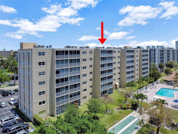Front view of a multi-story apartment building with balconies.