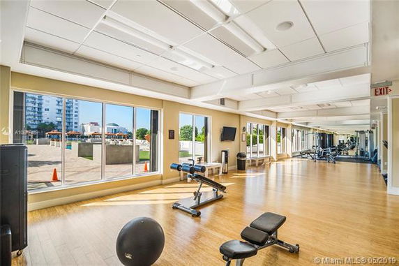 Spacious gym area with exercise equipment and large windows.