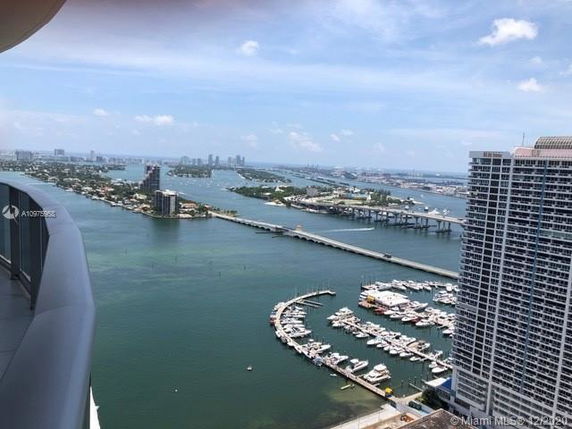 Panoramic view from a high-rise showing water, bridges, and a marina.